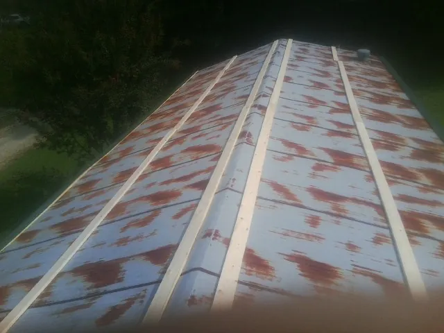 Rusted metal roof panels with new wood purlins before replacement — Storm Damage Roof Repair in Waccabuc by Roofing Brothers