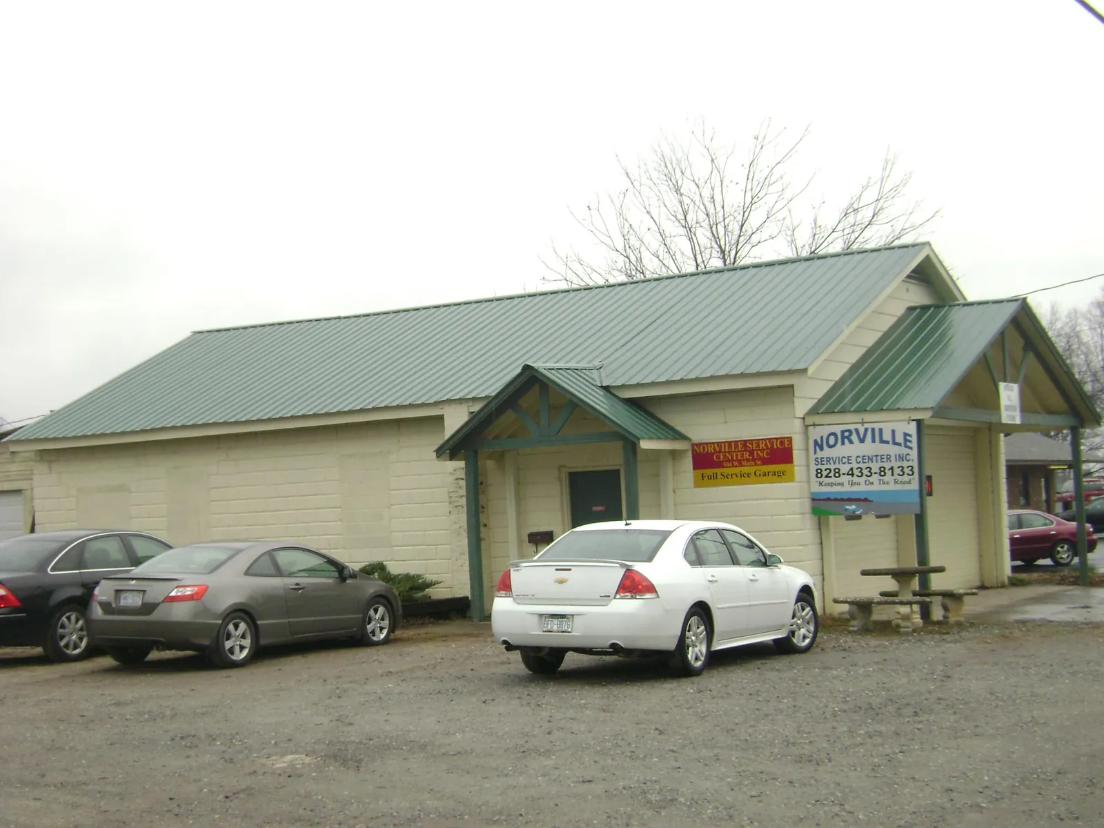 Green metal roof on a service garage with a covered entry in Waccabuc