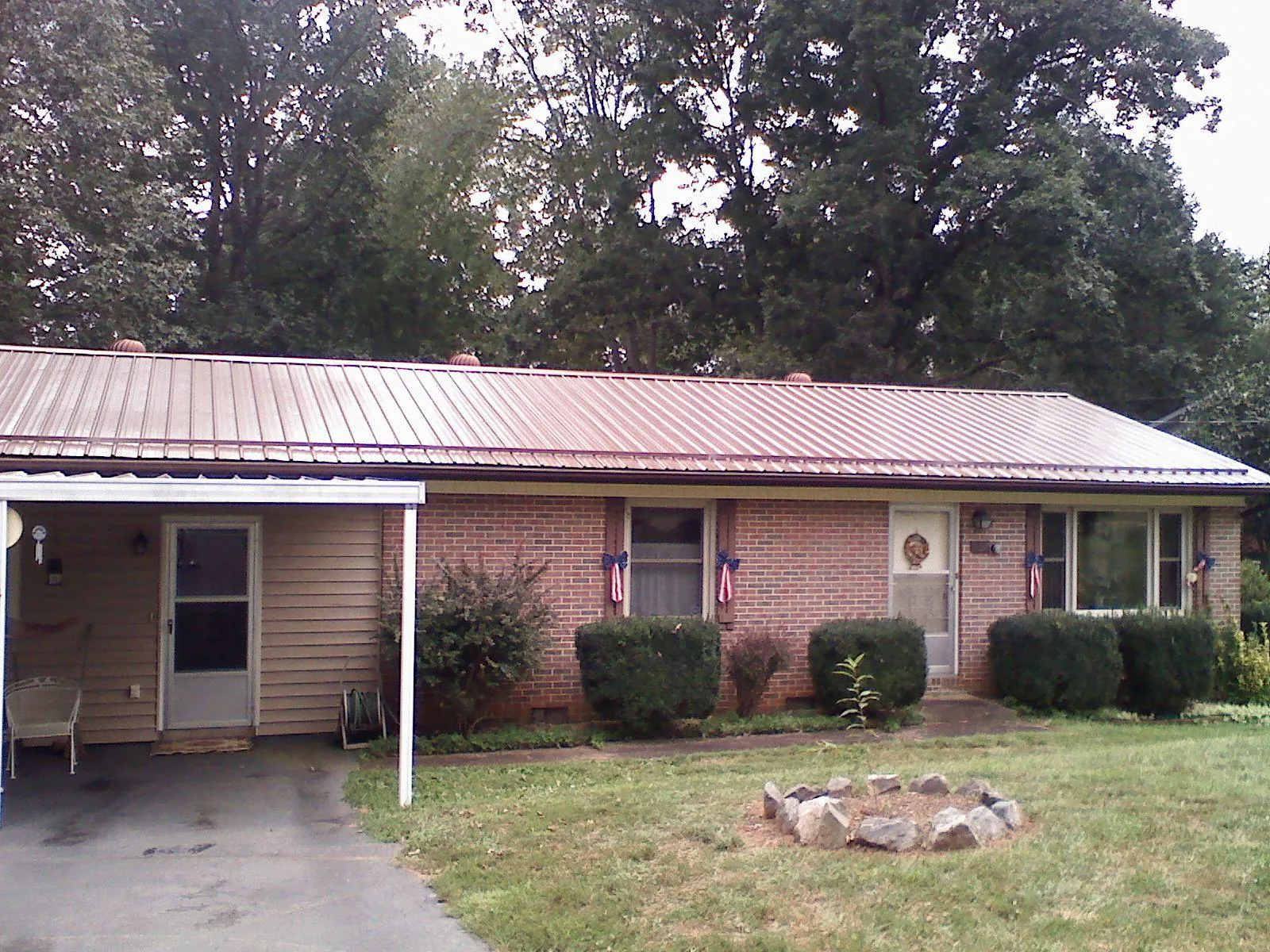 Bronze metal roof and carport on a brick ranch home — Roof Repair work by our crew in Waccabuc